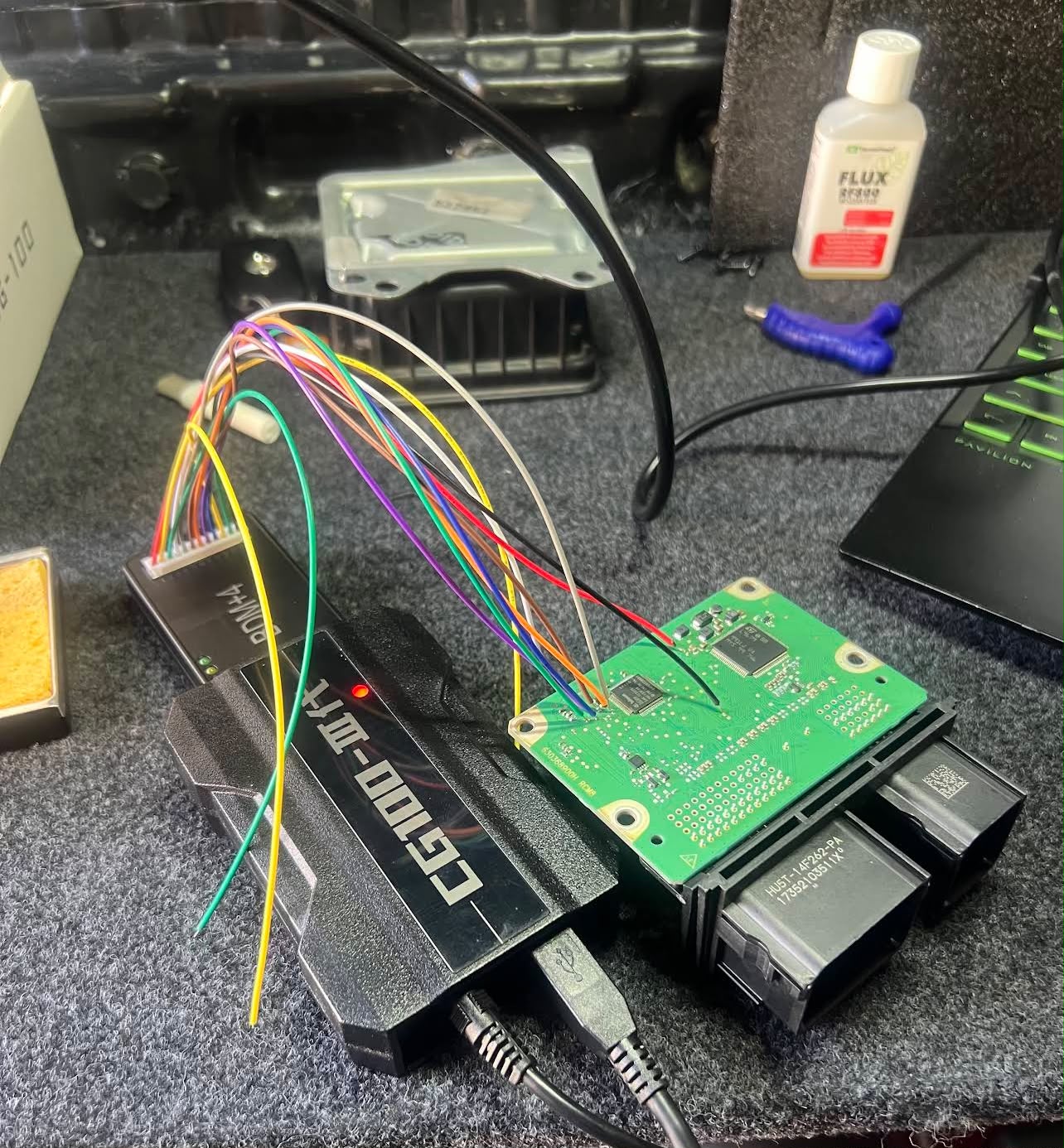 ECU circuit board wired to a bench programming tool