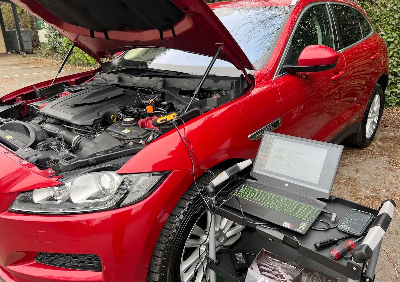 Red Jaguar F-Pace being diagnosed on a driveway